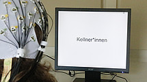 The picture shows a person in front of a computer screen: Electrodes attached to the head were used to measure the electrical activity of the brain when reading different sentence combinations