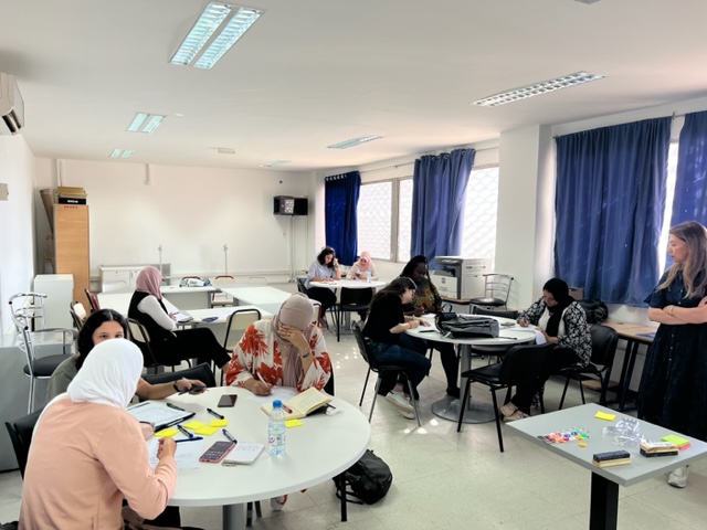 Tunesische Studierende arbeiten in Gruppen an einzelnen Tischen an Ideen für den Ideenwettbewerb