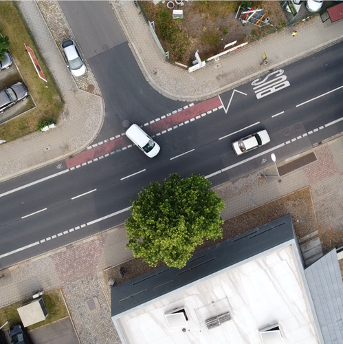 Eine Luftaufnahme einer mehrspurigen Verkehrskreuzung mit Fahrradinfrastruktur in einer deutschen Stadt.