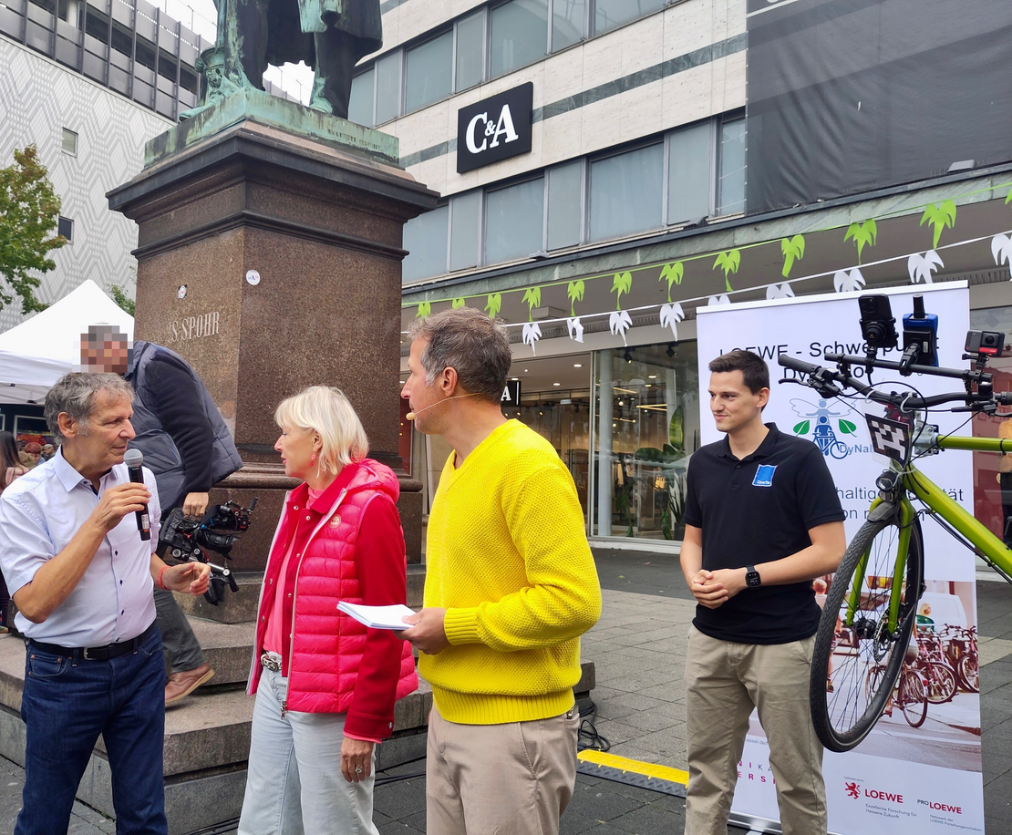 Digitalministerin Prof. Dr. Kristina Sinemus, Prof. Dr. Klaus David, Willi Weitzel und Lennart Busch vor dem Publikum der KI-Tour