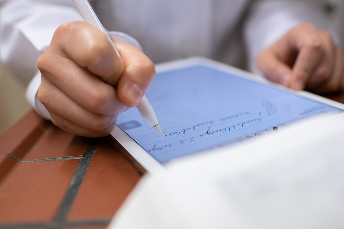 Person schreibt auf Tablet