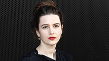 Portraitaufnahme von Leonie Hunter. dunkle hochgesteckte Haare, schwarzes Kleid, vor dunklem Hintergrund