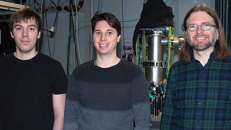 Das Foto zeigt Die Kasseler Physiker Fabian Westmeier, Nicolas Ladda, Arne Senftleben vor ihrer experimentellen Apparatur