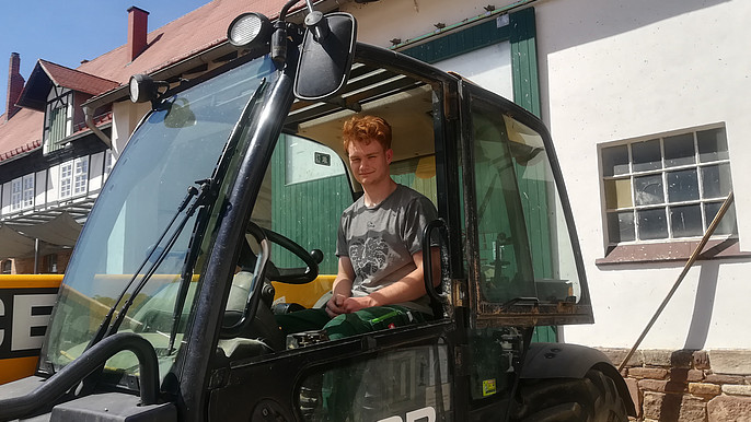 Azubi Alexander Herrmann beim Traktorfahren Mann fährt einen Traktor