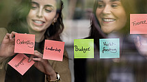 Two ladies behind Post-its.