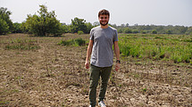 Roman Hinz vor afrikanischer Landschaft schaut lächelnd in die Kamera