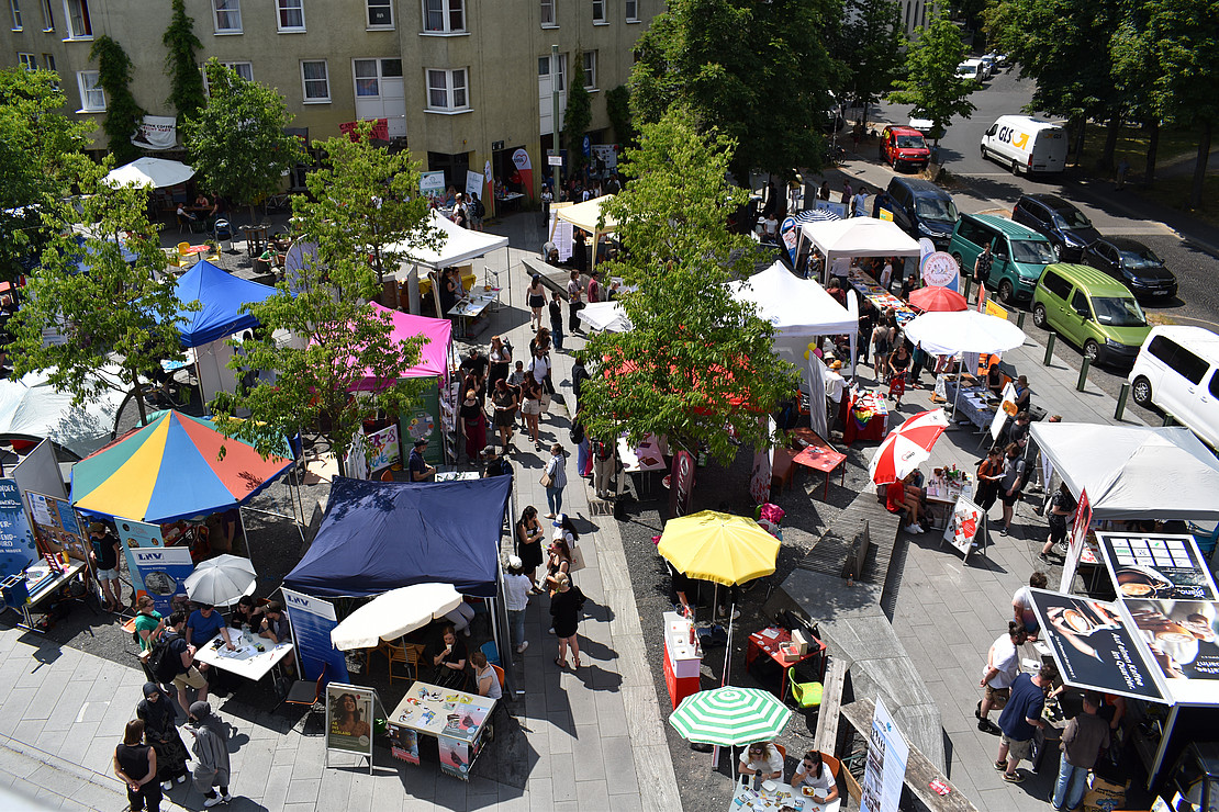 Aerial view of the square outside with trees, stands and people
