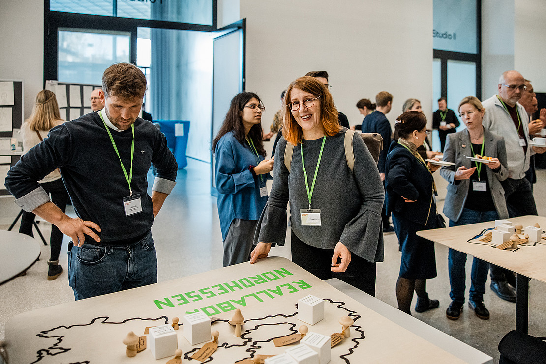 Gruppe vo Menschen an Tisch. 