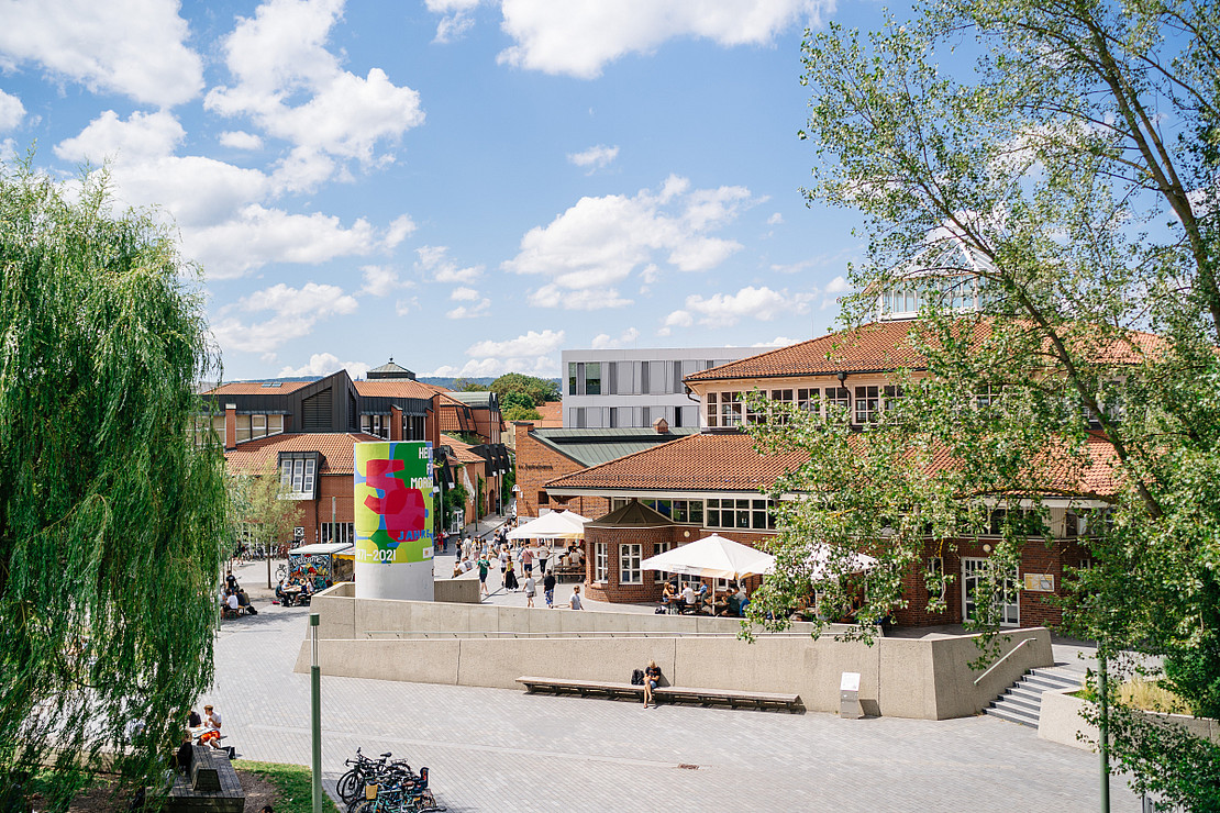 Blick auf den Mensavorplatz der Uni Kassel im Sommer bei Sonnenschein.