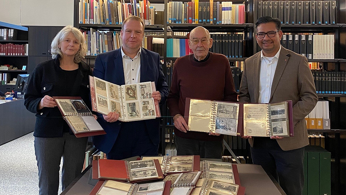 Die einzigartige Ansichtskartensammlung wird vorgestellt. V. l. n. r.: Claudia Martin-Konle (Leitende Bibliotheksdirektorin, UB Kassel), Dr. Timo Kirschberger (Sondersammlungen, UB Kassel), Dieter Rüsseler (Sammler und Vorbesitzer) und Manuel Büxenstein, (Vorstandsmitglied, Kasseler Sparkasse).