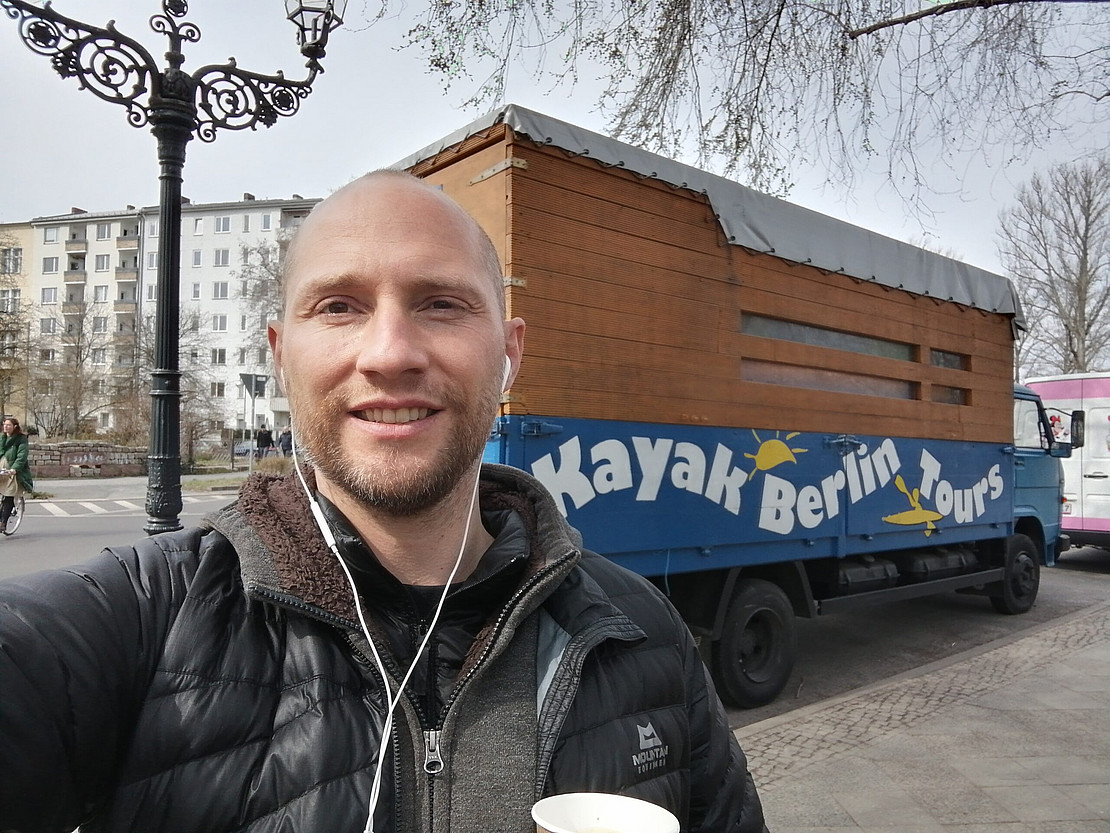 Selfie von Jörg Firnkorn vor Bauwagen mit Aufschrift "Kayak Berlin"